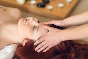 Obraz na płótnie Canvas Young woman having her head massaged at a spa center