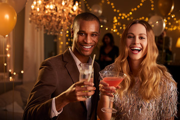 Portrait Of Couple With Drinks Enjoying Cocktail Party