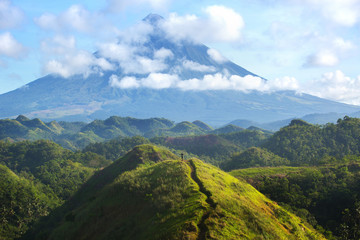 Obraz premium Hiker with backpack looks at the view on the Mayon volcano,Philippines