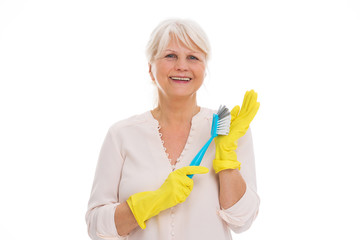 Senior woman with cleaning supplies and rubber gloves
