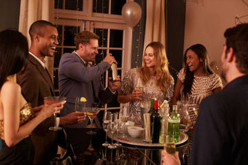 Man Making Cocktails For Friends At Party