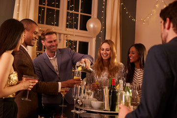 Man Making Cocktails For Friends At Party