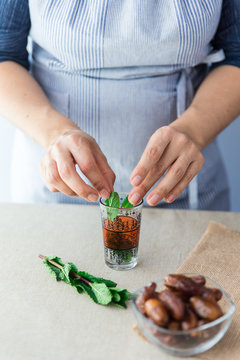 Crop cook putting leaves in small glass