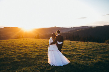 Fototapeta na wymiar Wedding couple are looking to the sunset