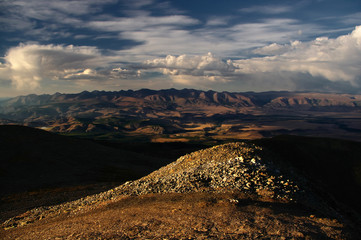 A top view to sunset highland yellow steppe plateau valley on a background of dramatic mountains ridges ranges under dawn white clouds and blue sky, Kurai, Altai, Siberia, Russia