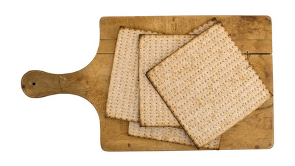 Top view of several whole wheat matzo crackers on an old cutting board.