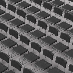 Neatly Aligned Black Leather and Steel Chairs on a Conference Carpet Floor