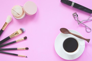 Obraz na płótnie Canvas Make up collection with a cup of hot coffee, Lifestyle concept on pink background