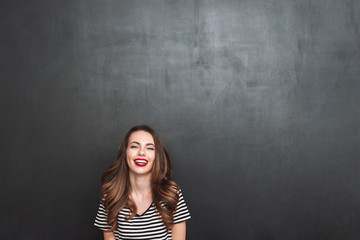 Laughing woman posing in studio and looking at camera