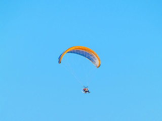 A man practicing extreme sport with paraglider with motor