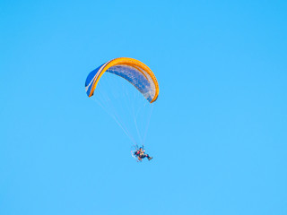 A man practicing extreme sport with paraglider with motor