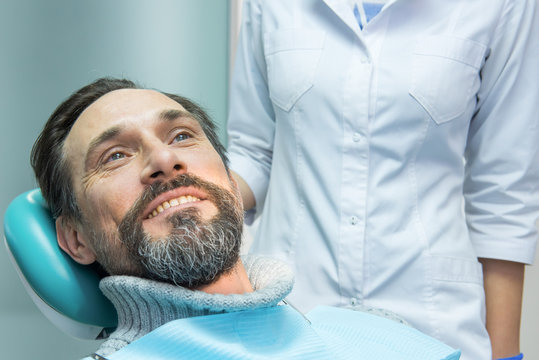 Mature male at the dentist. Patient of stomatologist. Health insurance tips.