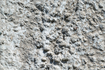 A piece of concrete wall with pebbles and stripes.
