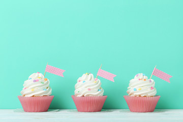 Tasty cupcakes on a green background