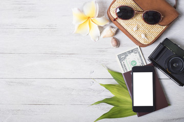 Holiday travel smart phone with accessories and costume on wood table. Empty space you can place your text or information.