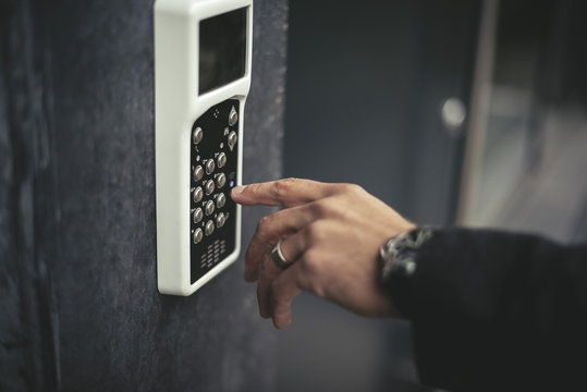 Cropped image of businessman's hand entering keycode