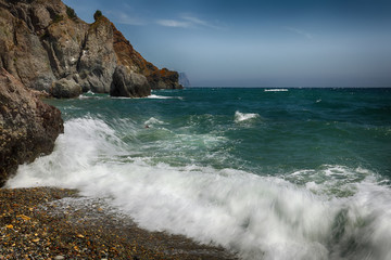 Rocky seashore and waves on a sunny day