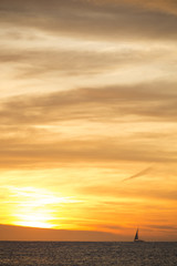 A photo of a sail boat in sunset