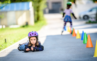 Child fell while learning to roller skate on the road.