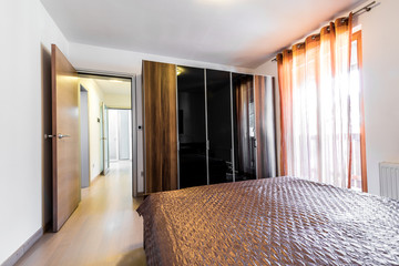 Modern hotel bedroom with bed and closet.
