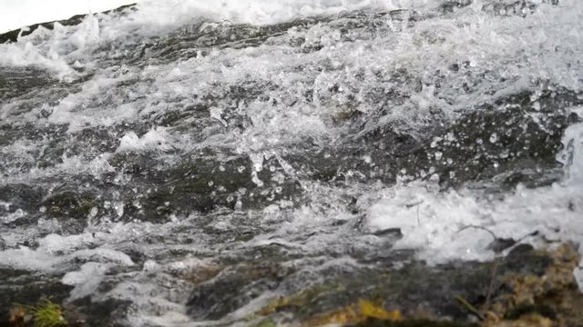 Super slow motion water floating down a cascade of a river, close, in HD