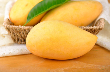 Naklejka na ściany i meble yellow mangoes on wooden background
