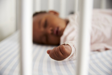 Close Up Of Baby Girl Sleeping In Nursery Cot - Powered by Adobe