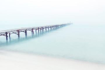 Holzsteg mit Meer und Nebel