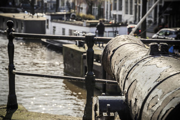 Fototapeta na wymiar Old cannon at Prinsengracht canal in Amsterdam, Netherlands