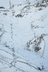 Ski Lift with people and ski slope.