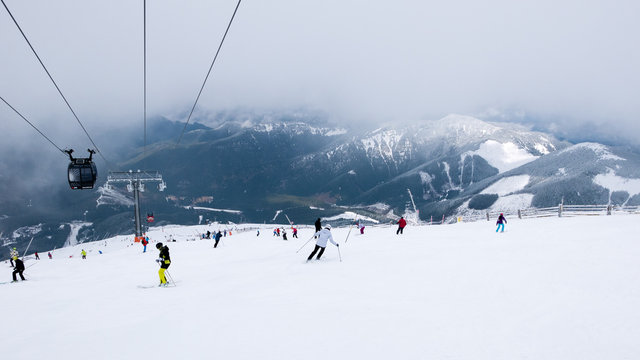 Cable car and skiers on the slope in ski resort Chopok in Slovakia. Tatra lower mountains.
