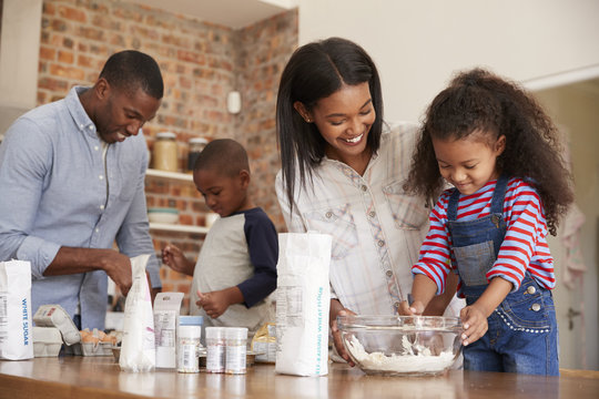 Parents And Children Baking Cakes In Kitchen Together