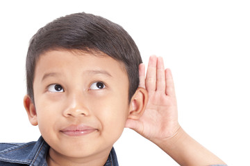 Little boy hearing something, hand to ear gesture on white background.