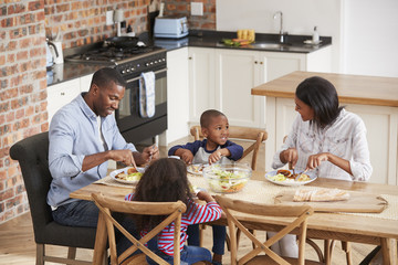 Family Eating Meal In Open Plan Kitchen Together
