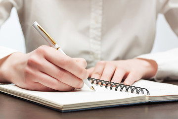 Business woman writing in notebook