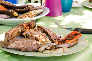 tavola con piatto di carne e verdure grigliate