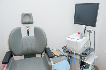 Interior of modern ENT clonic. Professional EVO ENT Medical Devices Workstation and chair in office. Ear Nose and Throat Medical equipment. Washing syringe. Selective focus