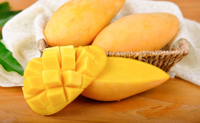 yellow mangoes on wooden background