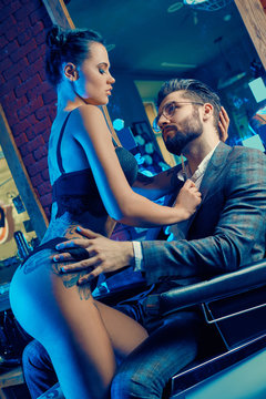 Brutal man in elegant suit and sexy girl with tattoo