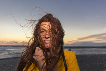 Young beautiful long hair woman on windy seashore