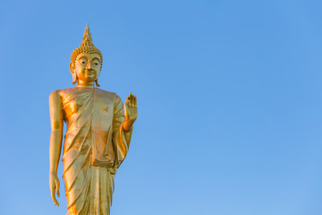 The standing buddha statue on blue sky, located in Chanthaburi, Thailand.