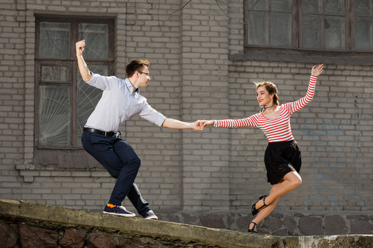 Young Couple Dancing Swing Outside In Front Of Old Brick House