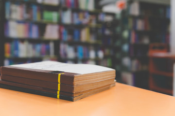 A stack of old books on table with blur book in library, education background