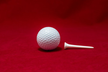 One golf ball and one pin and red flannel background