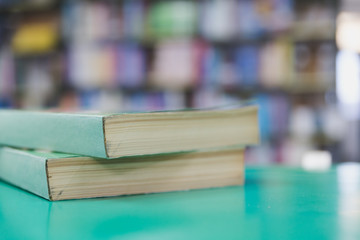 A stack of old books on table with blur book in library, education background
