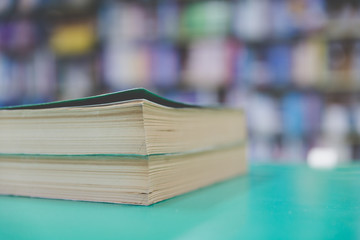 A stack of old books on table with blur book in library, education background