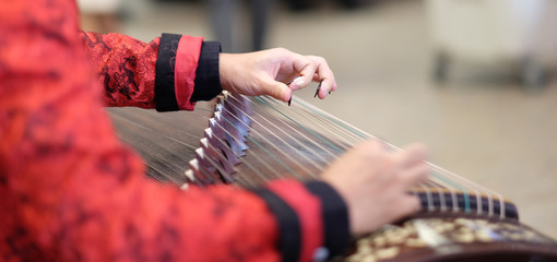 hand of man playing Guzheng.The guzheng or gu zheng, also simply called zheng, is a Chinese...
