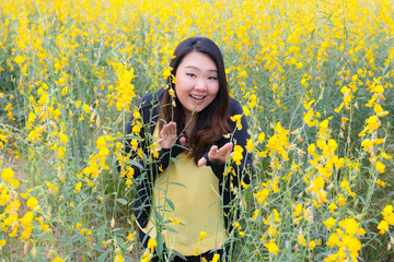 Portrait of beautiful happy fat woman touching sunn hemp happily in the flower garden