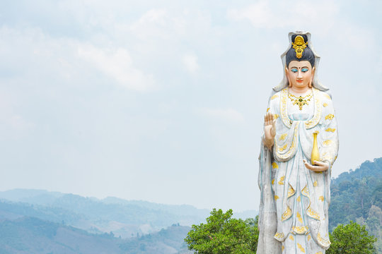 Quan Yin, the goddess of compassion and mercy, statue standing on the top of hill.