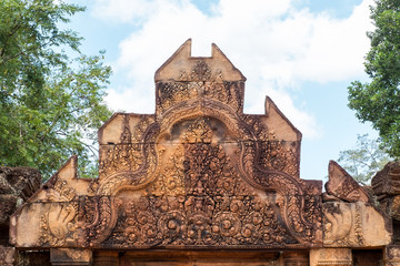 Obraz premium Ancient isosceles pink stone Carving of kala, mythical creature representative of time and of the god Siva in Banteay Srei, Siem reap, Cambodia.
